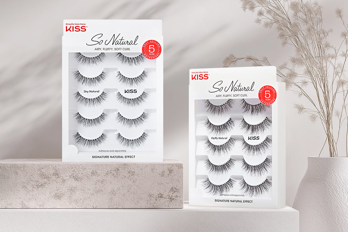 KISS So Natural false eyelash multipack sets displayed on white shelving with dried flowers.
