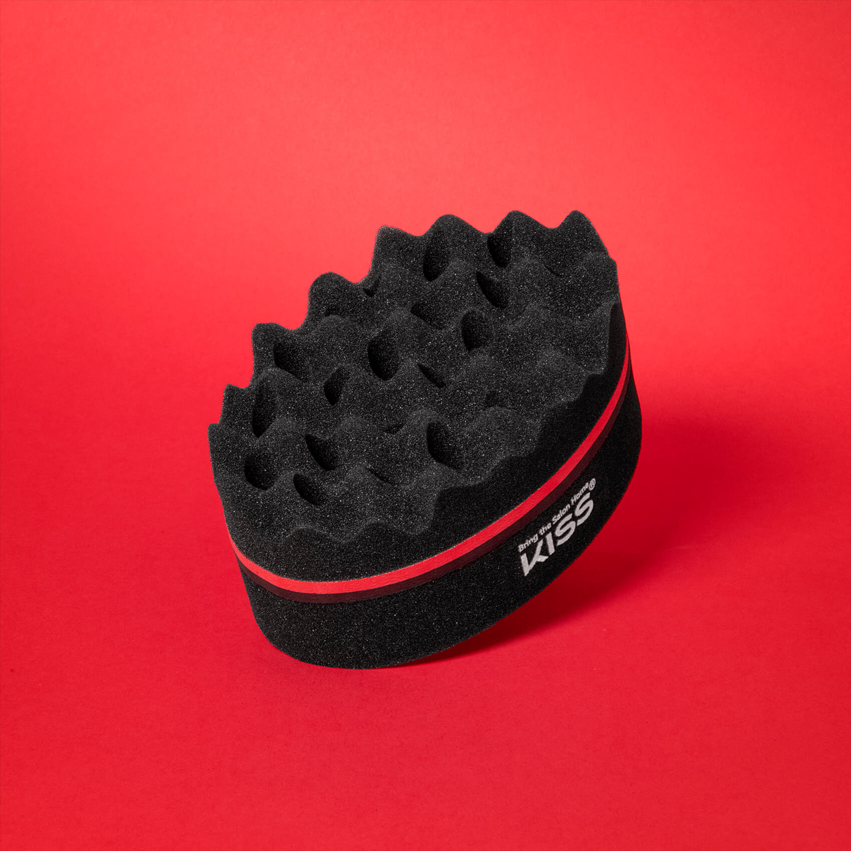 Black, dual-sided twist sponge with textured, wavy surface on top and smooth bottom, featuring a red stripe and white KISS logo on the side.