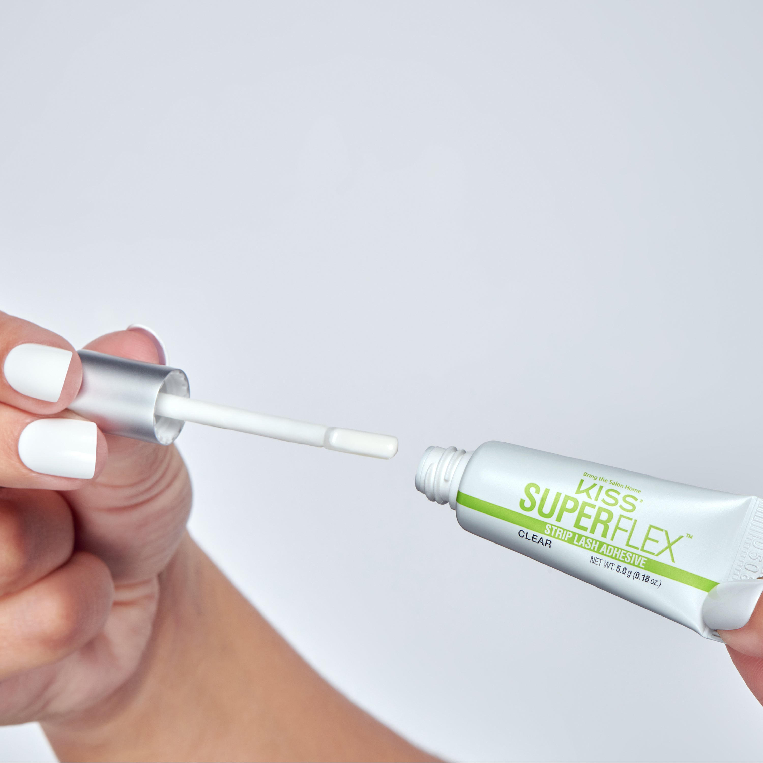 Kiss SuperFlex Strip Lash Adhesive being applied with brush applicator to false lashes.