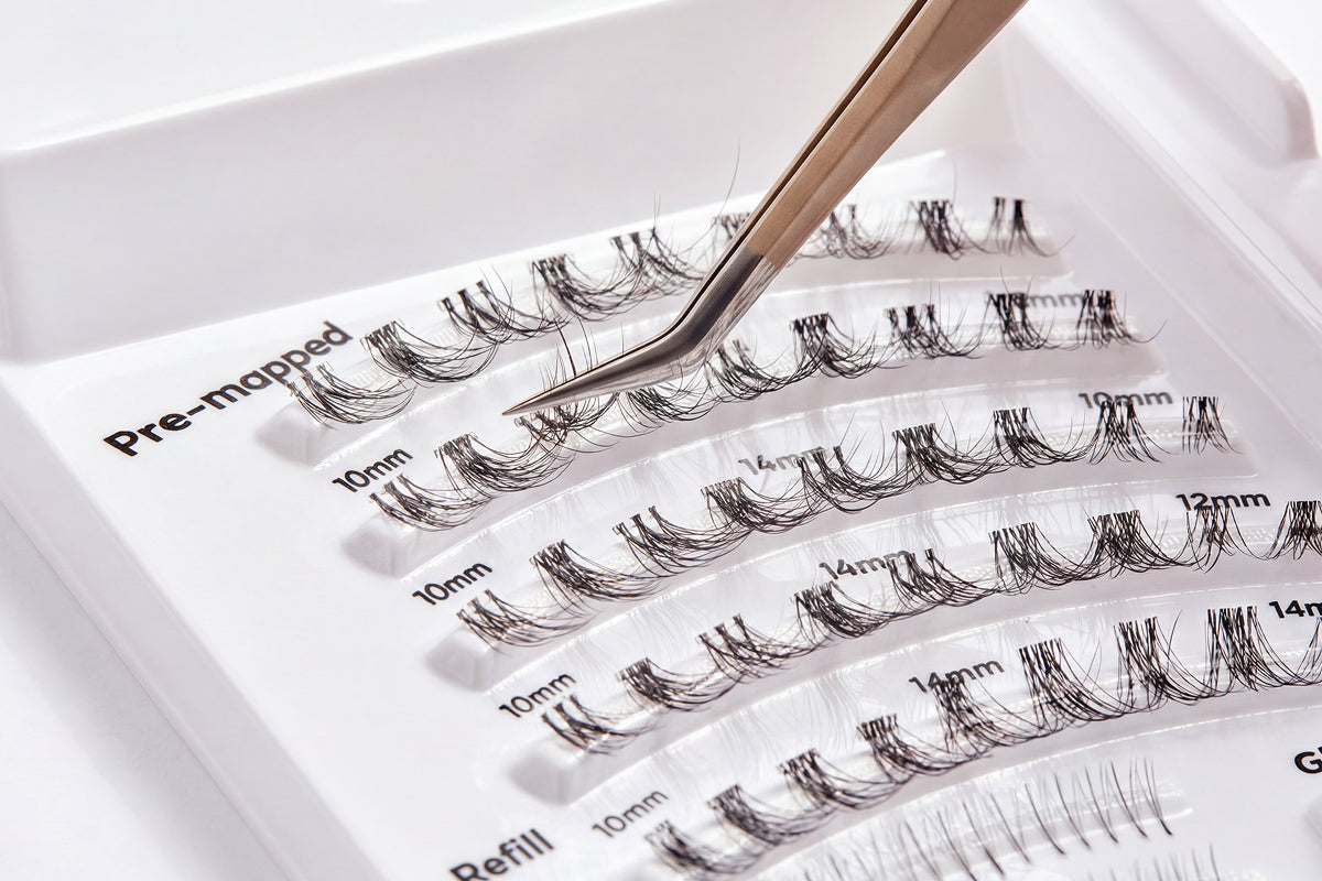 Set of false eyelashes with a镊ine on a white tray