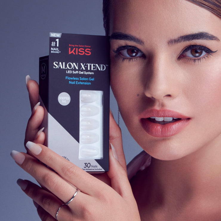 Woman holding KISS Salon Xtend LED Soft Gel nail extension box with 30 nails.