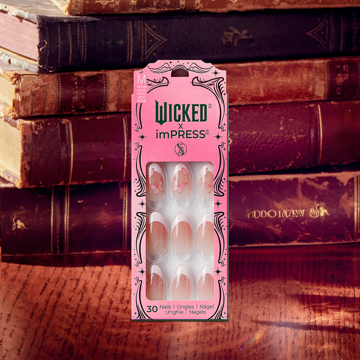Wicked x imPRESS press-on nails package displayed against vintage books.