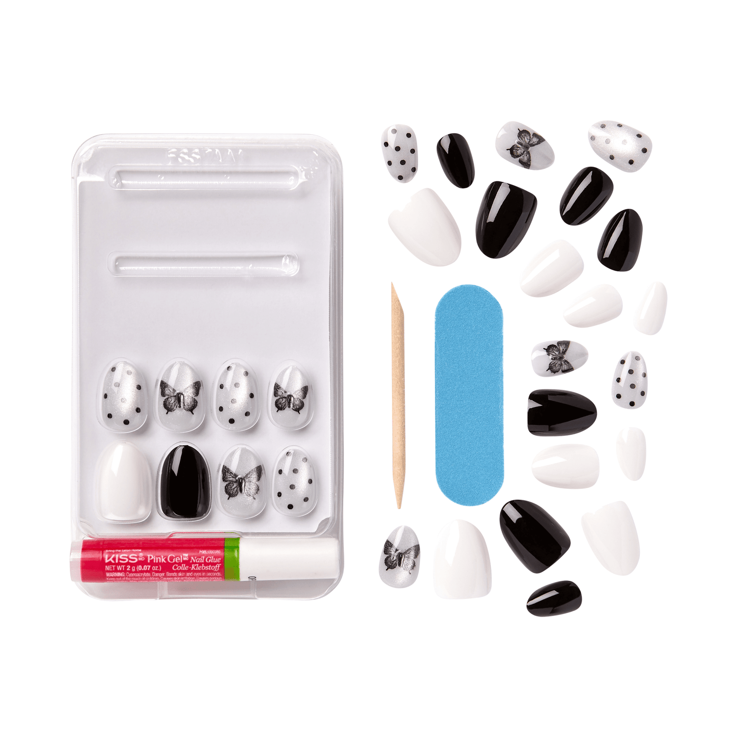 The image shows a set of artificial nails and nail care tools. The set includes various artificial nails in different designs and colors, primarily black and white. Some nails feature polka dots, while others have bow designs. The set also includes a small wooden cuticle stick, a blue nail file, and a small tube of adhesive. The artificial nails are arranged neatly in a plastic tray, with additional nails scattered around the tray.