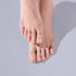 Two feet with natural pink nail polish against a light gray background.
