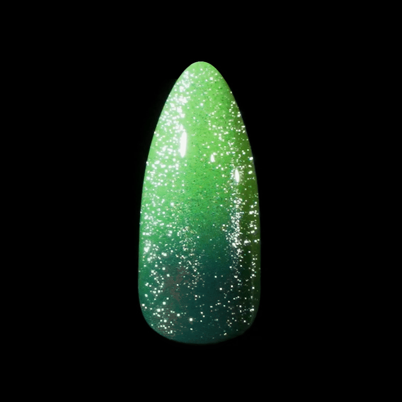 Glossy stiletto-shaped nail tip showcasing a gradient polish from bright green to dark teal with fine white glitter speckles throughout.