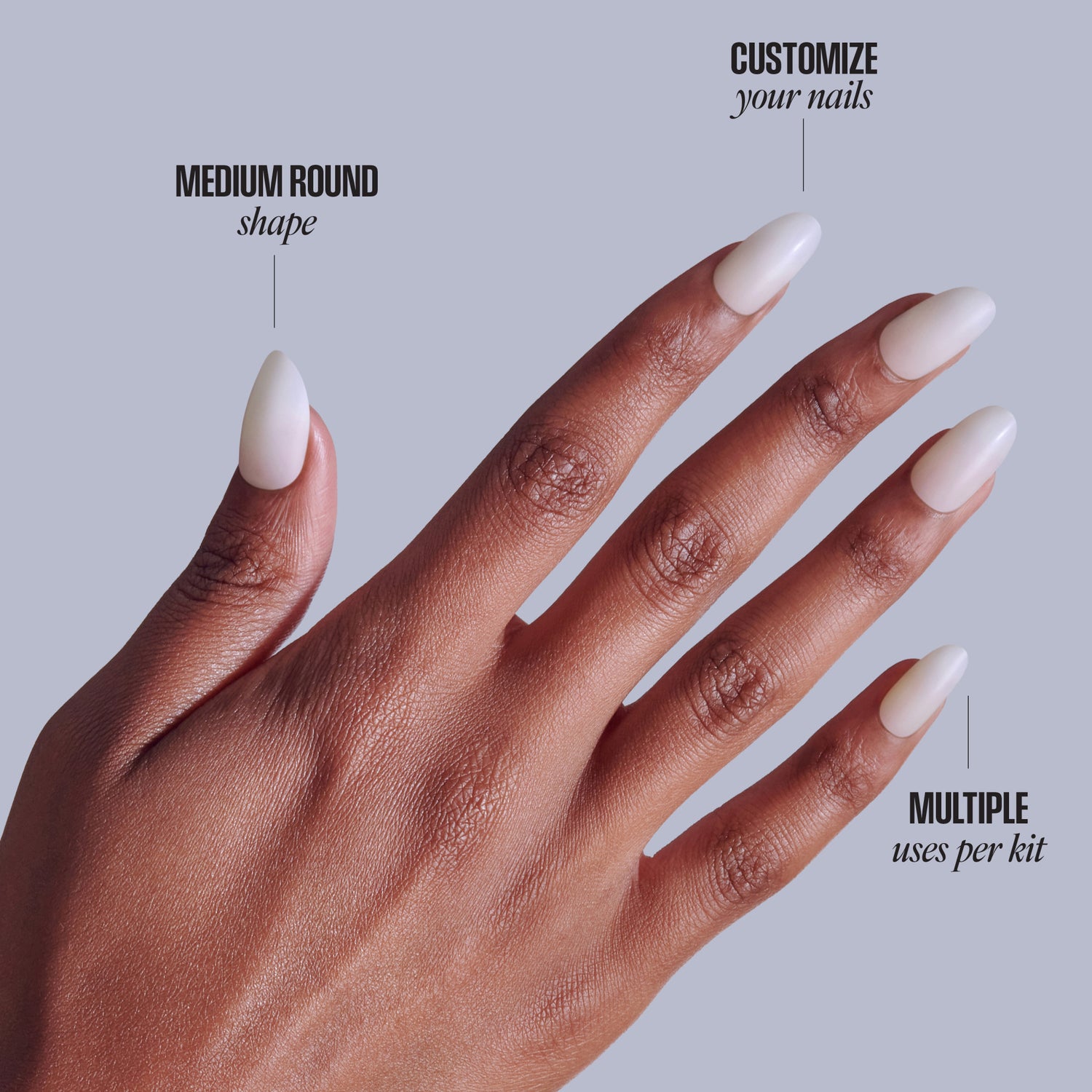 Medium round white ombre press-on nails on dark skin hand against gray background.