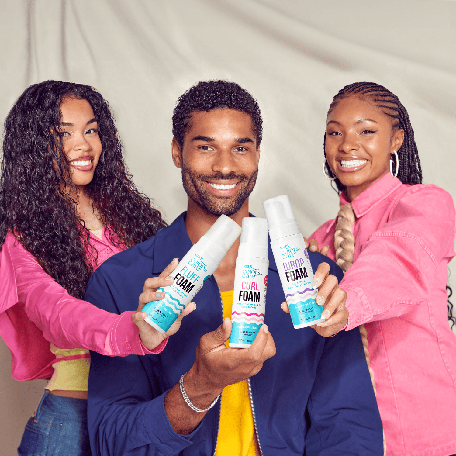 Three people holding Colors &amp; Care Curl Foam hair products against neutral background.