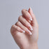 Almond-shaped nails with white tips and gold celestial designs on pink base.
