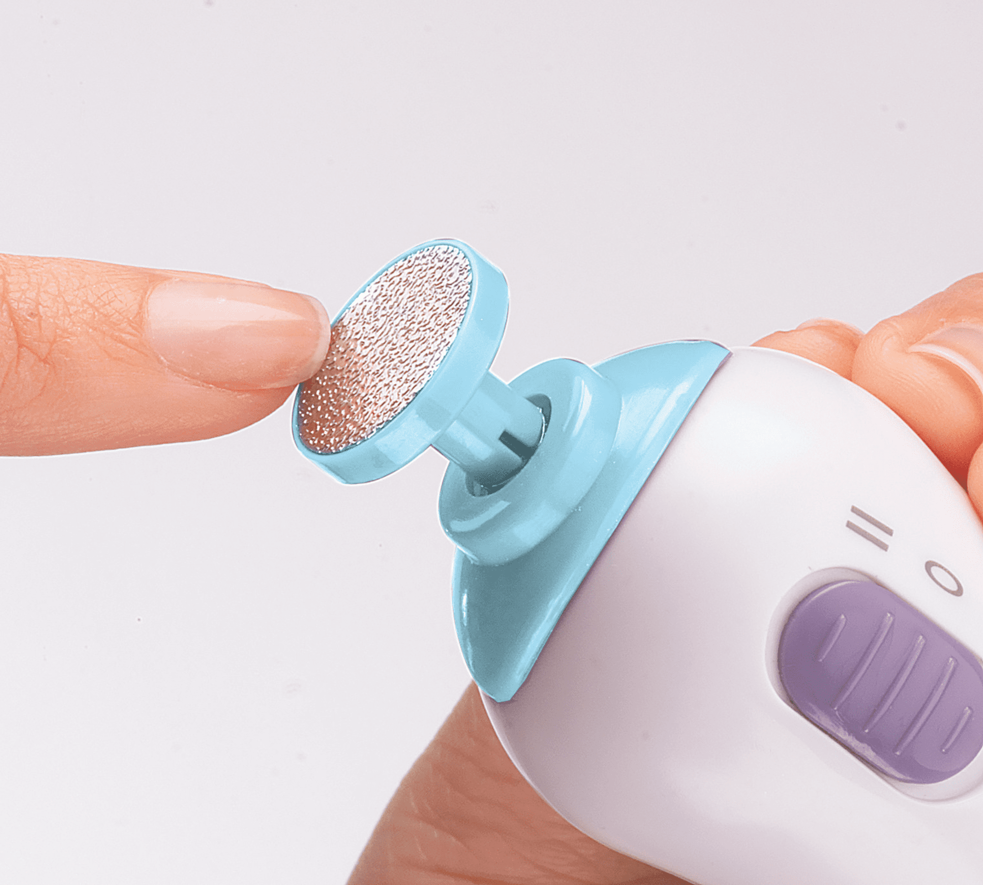 Small handheld KISS PowerFile To Go nail file with a circular blue filing surface touching a natural fingernail, featuring an on/off purple slider.
