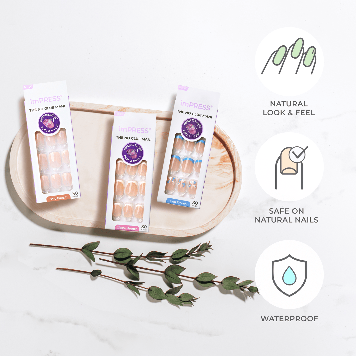 Three packages of imPRESS press-on nails in Bare French, Classic French, and Mod French designs are displayed on a beige tray, accompanied by green leafy sprigs. The text highlights that the nails offer a natural look and feel, are safe on natural nails, and are waterproof.