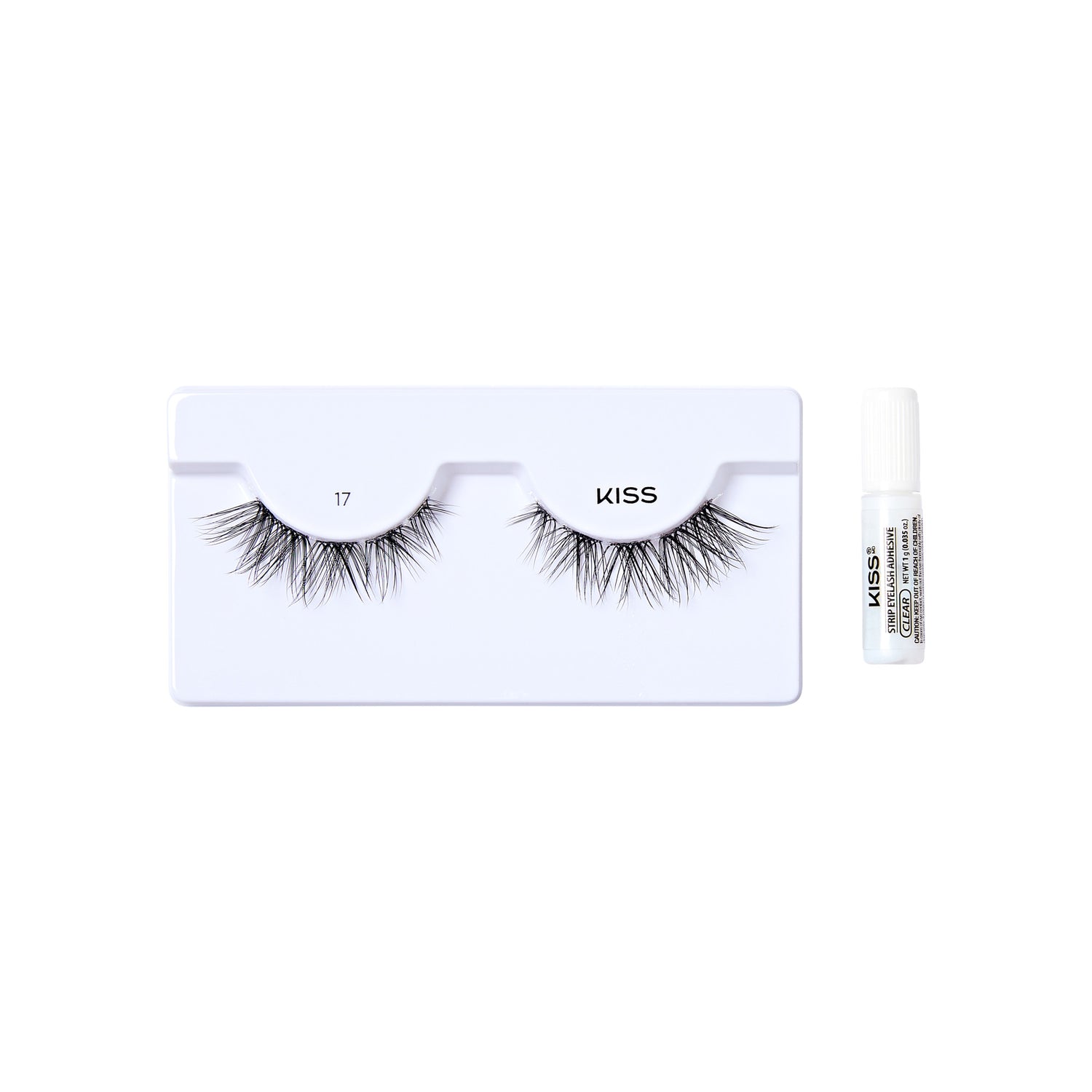 The image shows a set of false eyelashes from the brand "KISS." The eyelashes are displayed on a white plastic tray, with the number "17" printed on the left side of the tray. To the right of the tray, there is a small tube of adhesive glue, also branded with "KISS." The eyelashes appear to be voluminous and have a natural, wispy look.