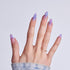 Hand displaying purple gradient nail art with rhinestone accents and star designs