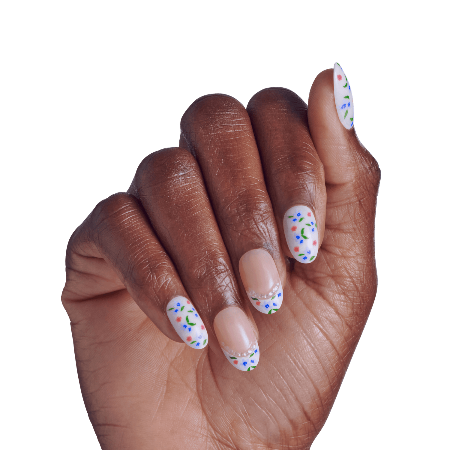 Hand displaying manicure with white oval nails and colorful floral nail art design.