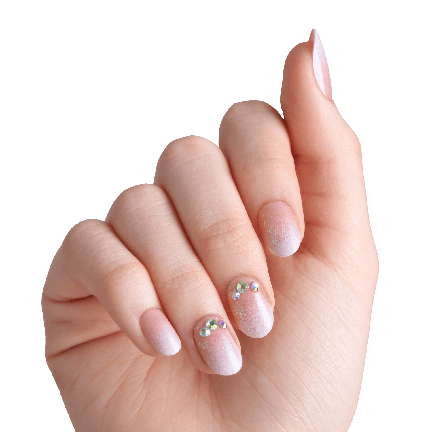 Manicured hand with almond nails, nude pink polish, rhinestone accents on middle and ring fingers.