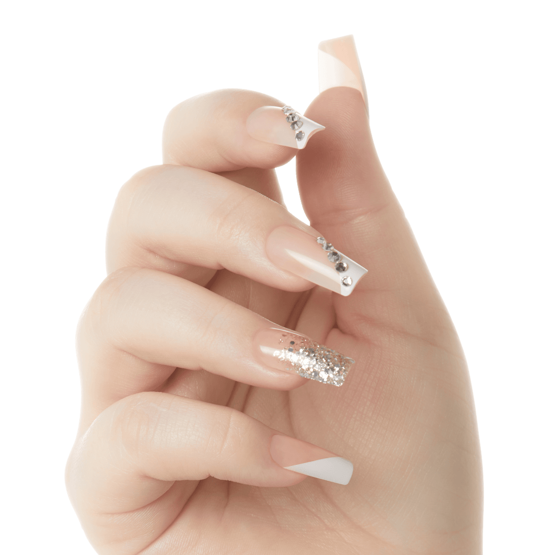 Hand displaying five glossy press-on nails with a nude base color; three nails have rhinestone accents, one nail has silver glitter, and one has a white diagonal tip design.