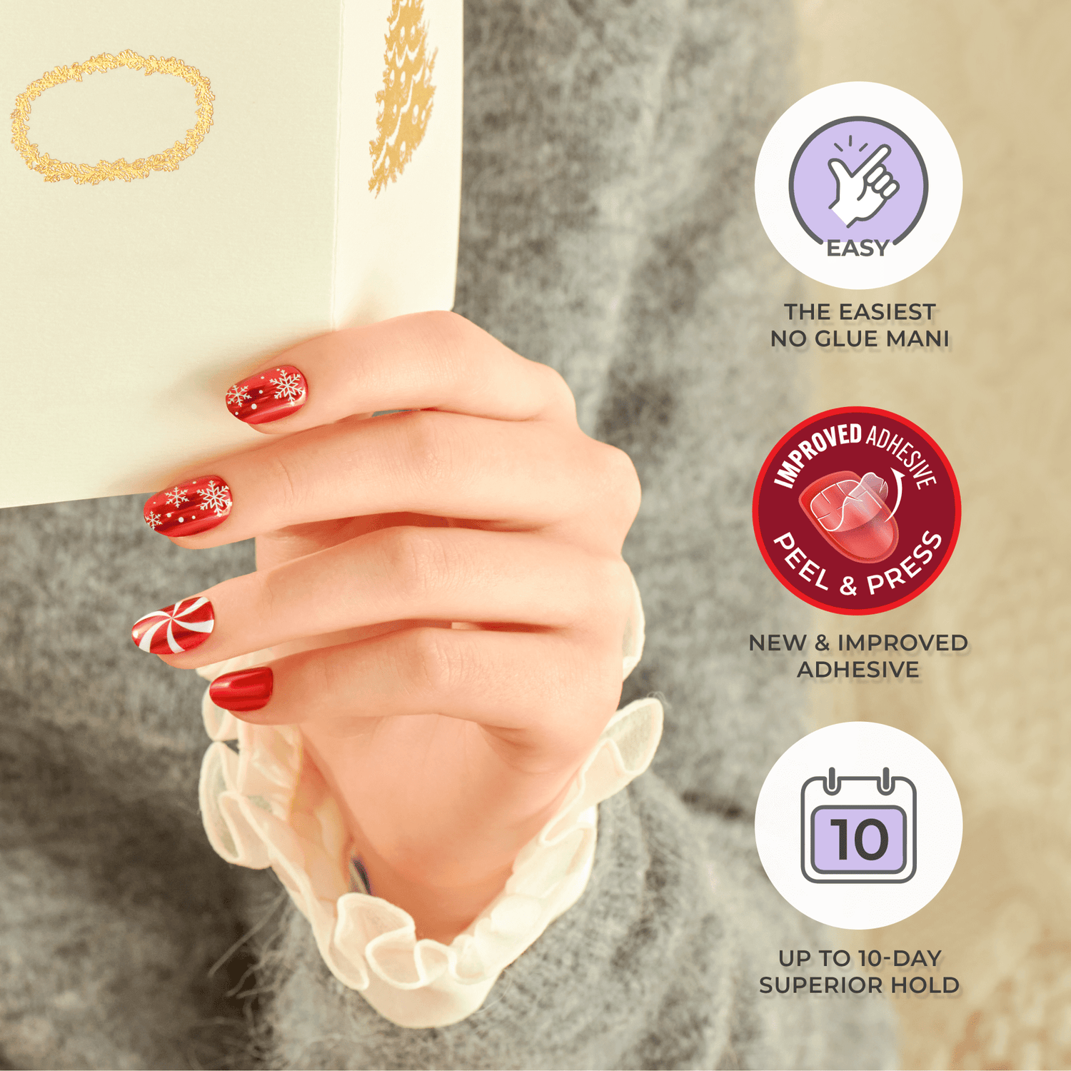 Hand with red holiday-themed press-on nails featuring white snowflakes and a peppermint swirl design, holding a cream-colored gift box. Text highlights easy no-glue application, improved peel-and-press adhesive, and up to 10-day hold.