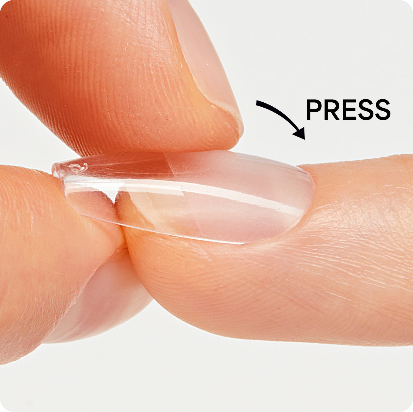 Close-up of fingers holding a clear contact lens with 'PRESS' instruction on a light gray background.