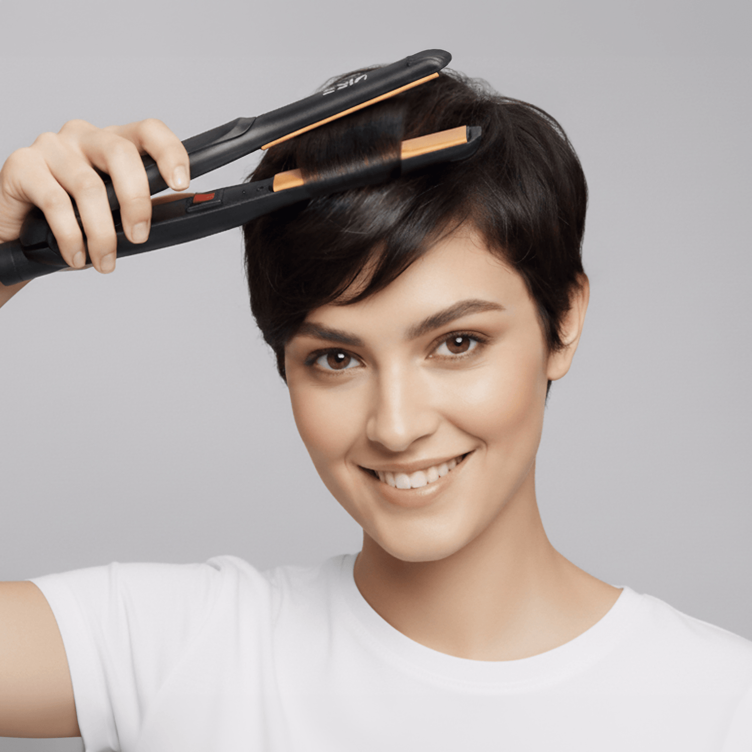 Woman with short dark hair smiles while using a black and copper KISS Tourmaline Ceramic 1/2\