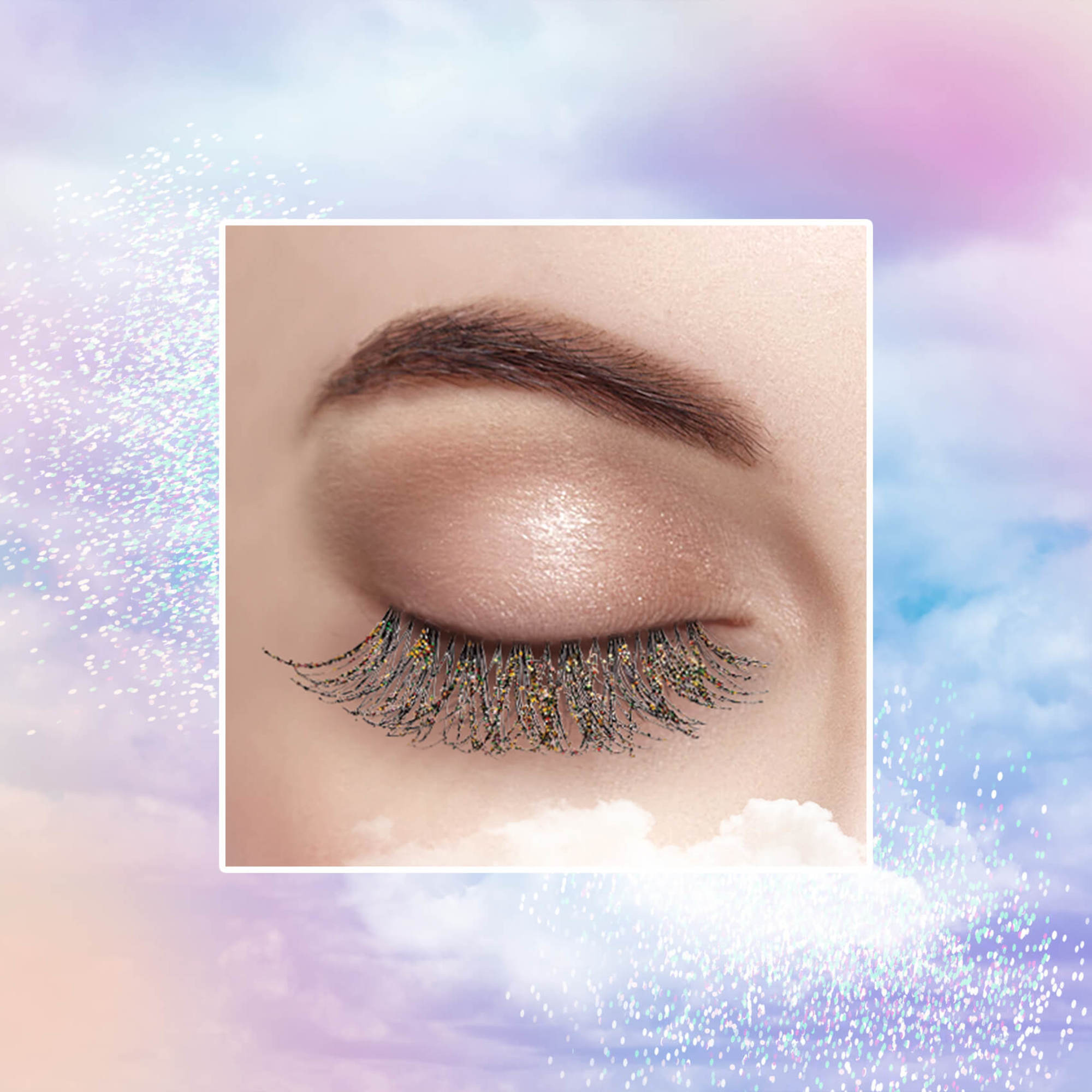 Close-up of a closed eye wearing black false eyelashes decorated with fine multicolored glitter on a soft pastel cloud background.