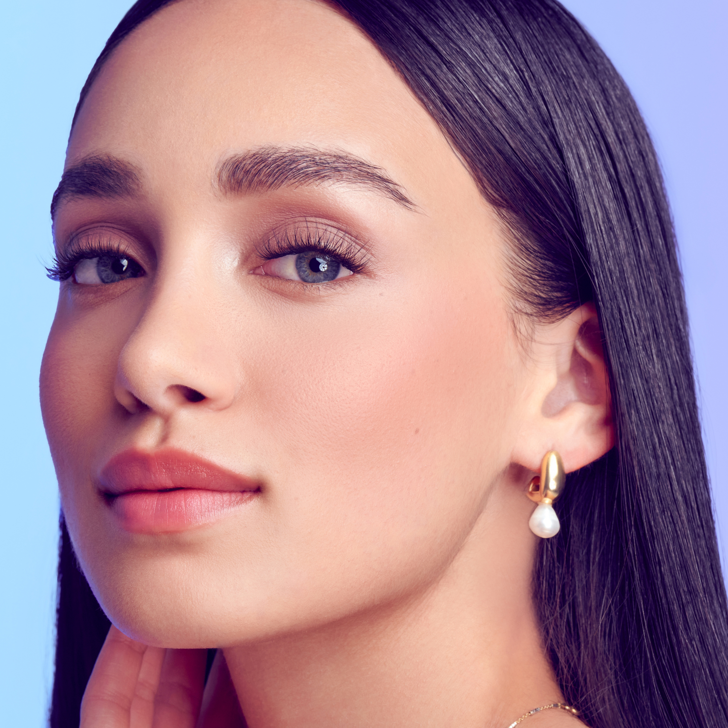 Close-up of a woman with smooth skin and defined eyelashes, showcasing natural-looking makeup and long lashes enhanced by the KISS FALSCARA Studio InfuseBond &amp; Water-Resistant Seal.