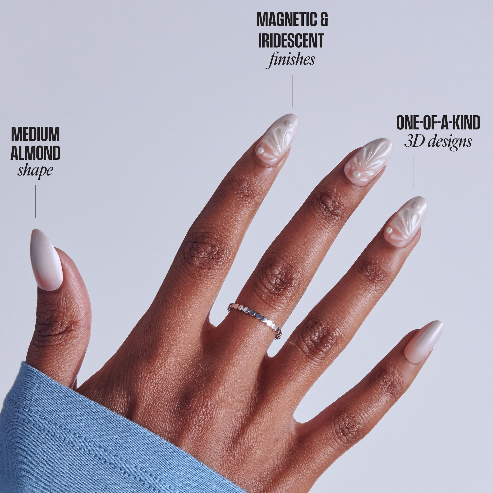 Medium almond nails with magnetic iridescent 3D designs on deep skin tone hand.