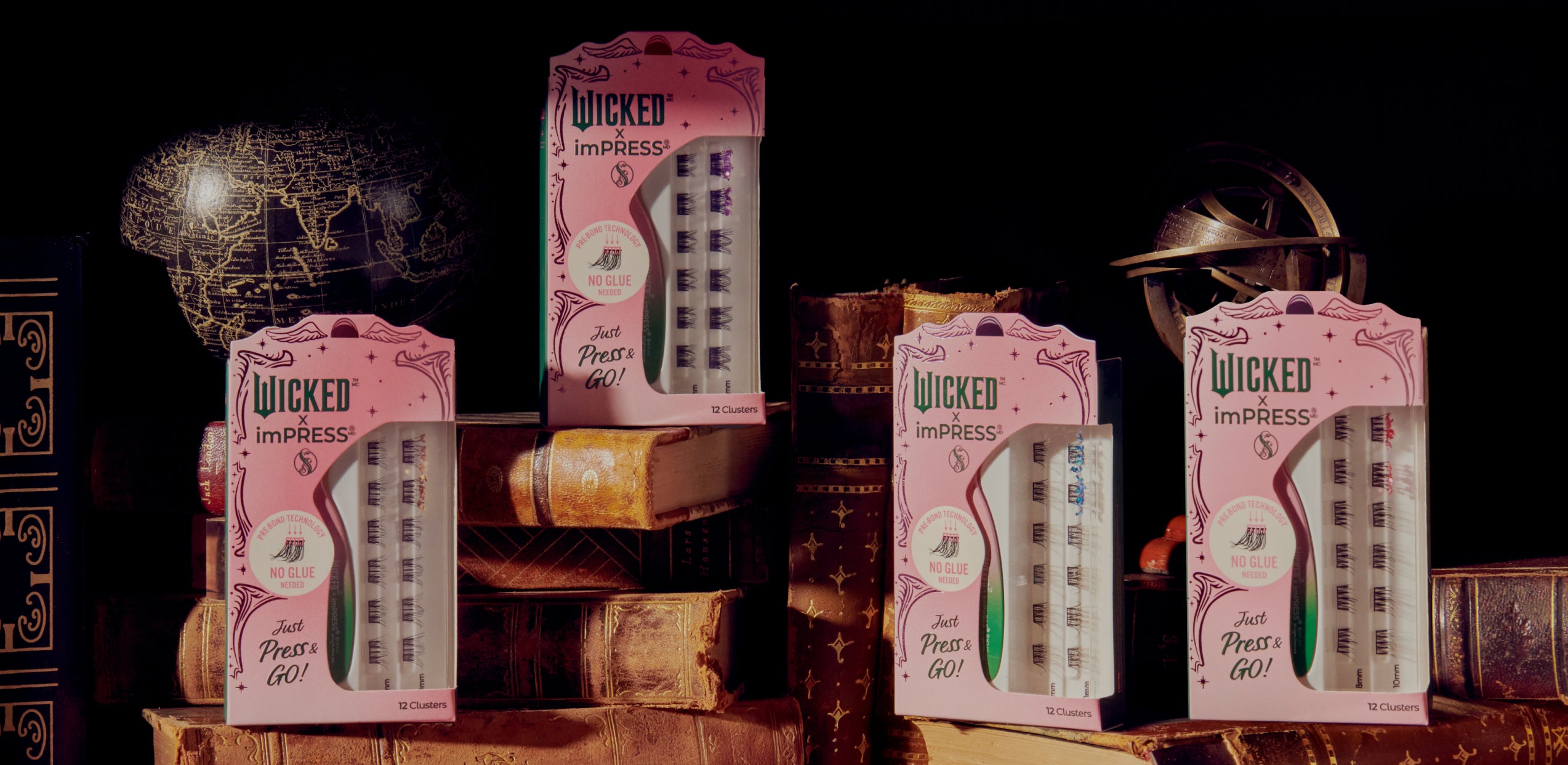 Wicked x imPRESS press-on lashes displayed on vintage books and globe props.