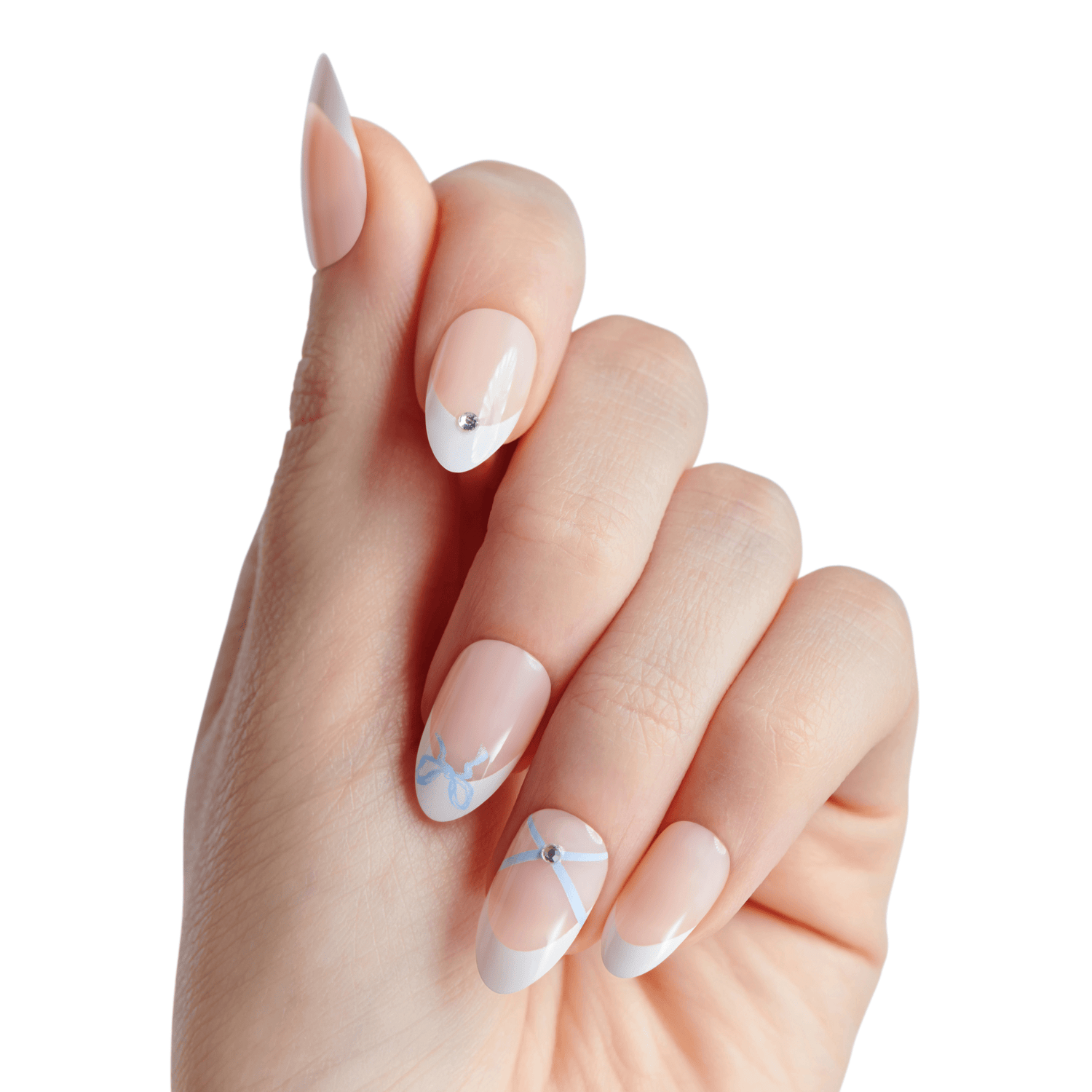 Hand with press-on nails featuring a nude base, white French tips, small rhinestones, and delicate light blue ribbon designs on two nails.