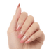 Hand showing five press-on gel nails with an ombre design fading from clear nude at the base to soft pink tips with subtle sparkles.