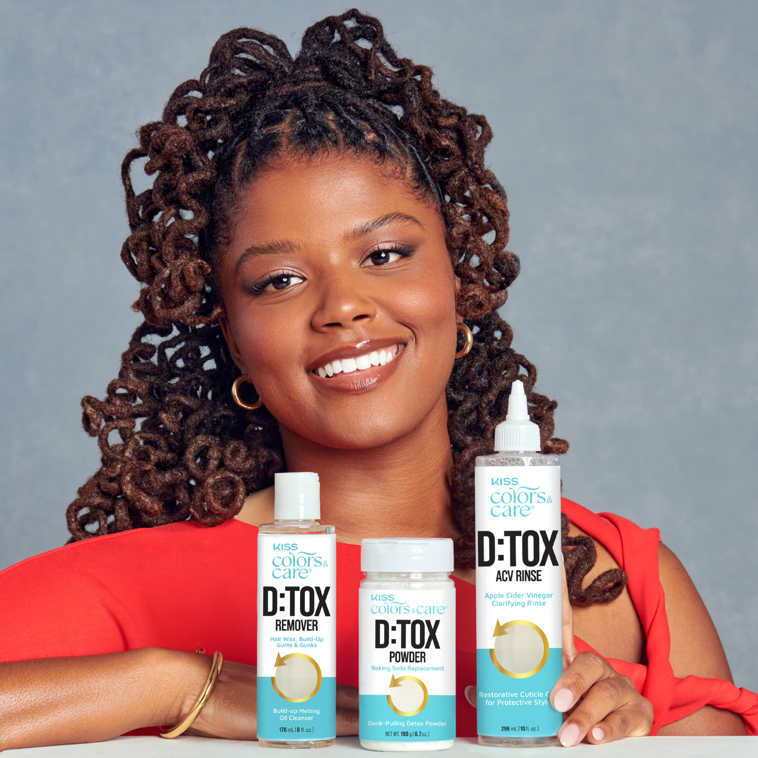 Woman holding hair care products with a gray background