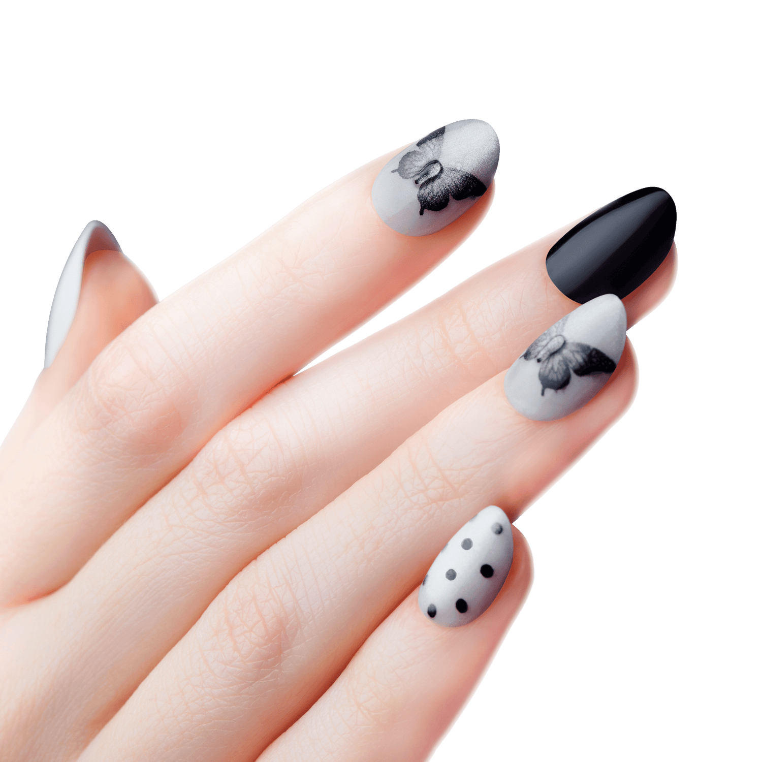 Hand with matte press-on nails in mocha and black colors, featuring black butterfly designs and black polka dots on a light gray background.
