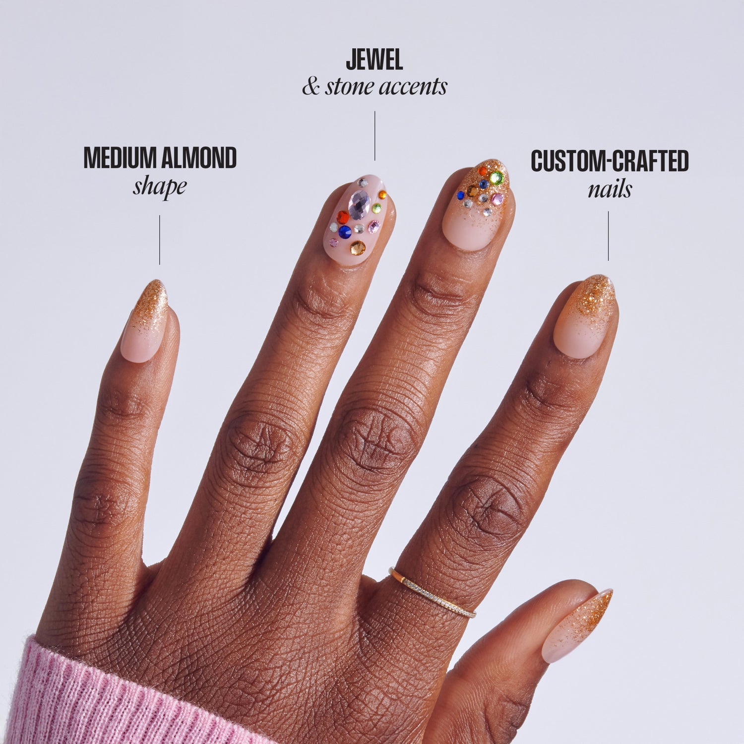 Hand displaying three nail designs: medium almond shape, jewel &amp; stone accents, custom-crafted nails with gold glitter.