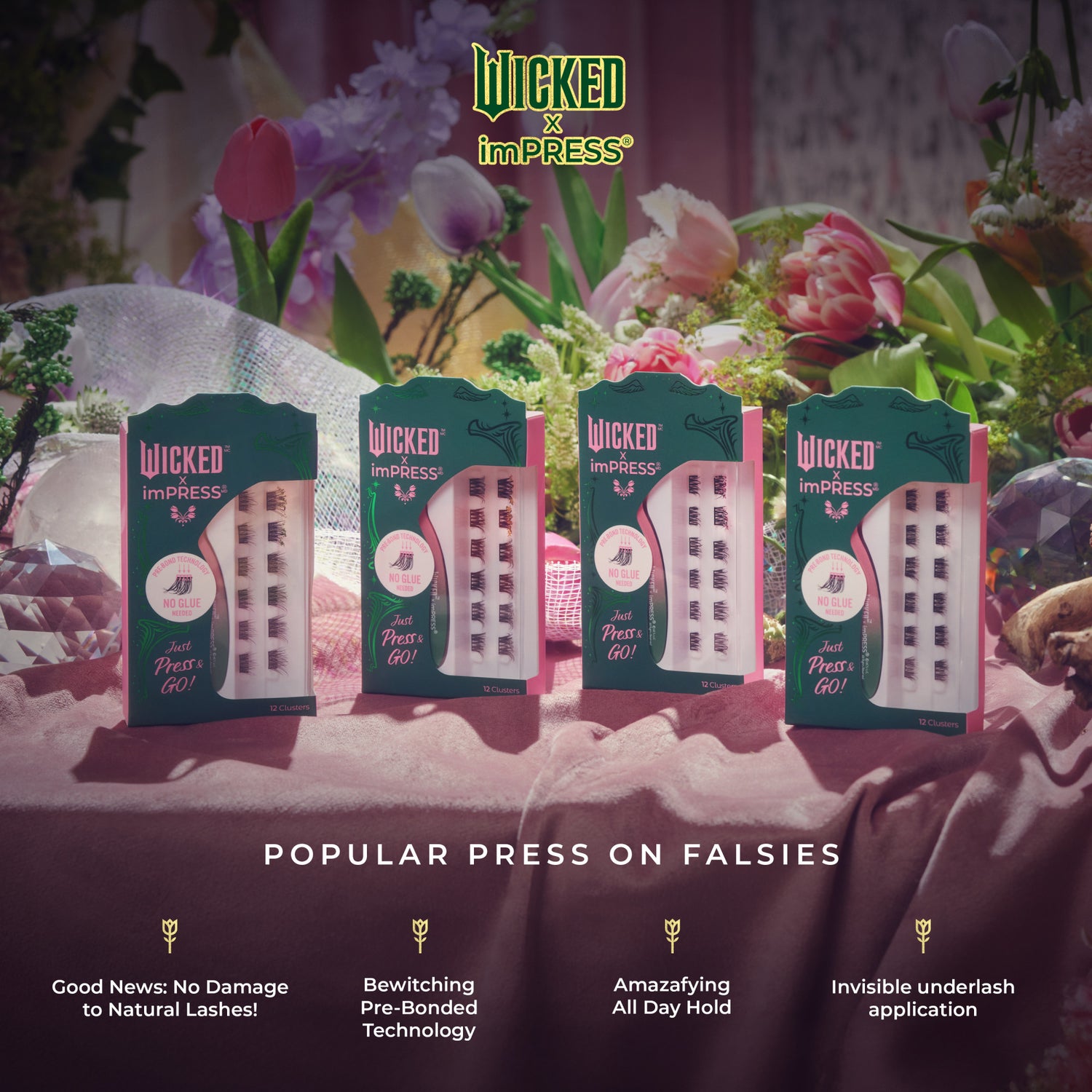 Four green and pink packages of WICKED X imPRESS Bewitching false eyelash clusters displayed on a pink velvet surface with flowers in the background.