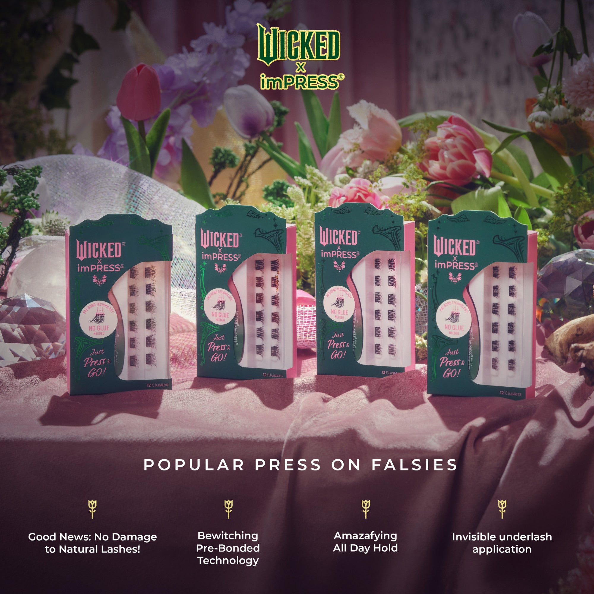 Four green and pink packages of WICKED X imPRESS Bewitching false eyelash clusters displayed on a pink velvet surface with flowers in the background.