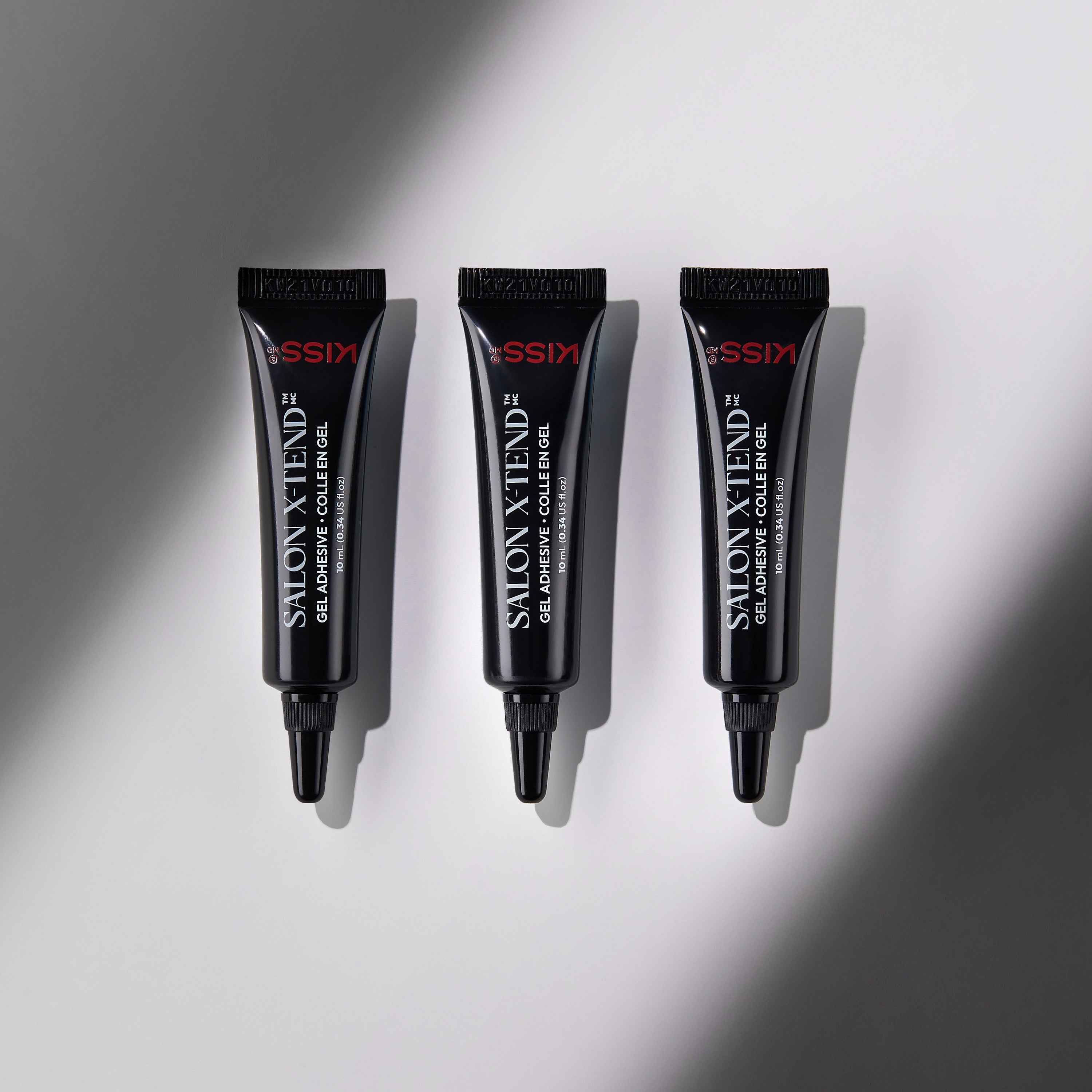 Three black tubes of KISS Salon X-tend LED Gel Adhesive, each labeled with product name and volume 10 mL (0.34 US fl oz), arranged vertically on a light gray background with soft shadow.