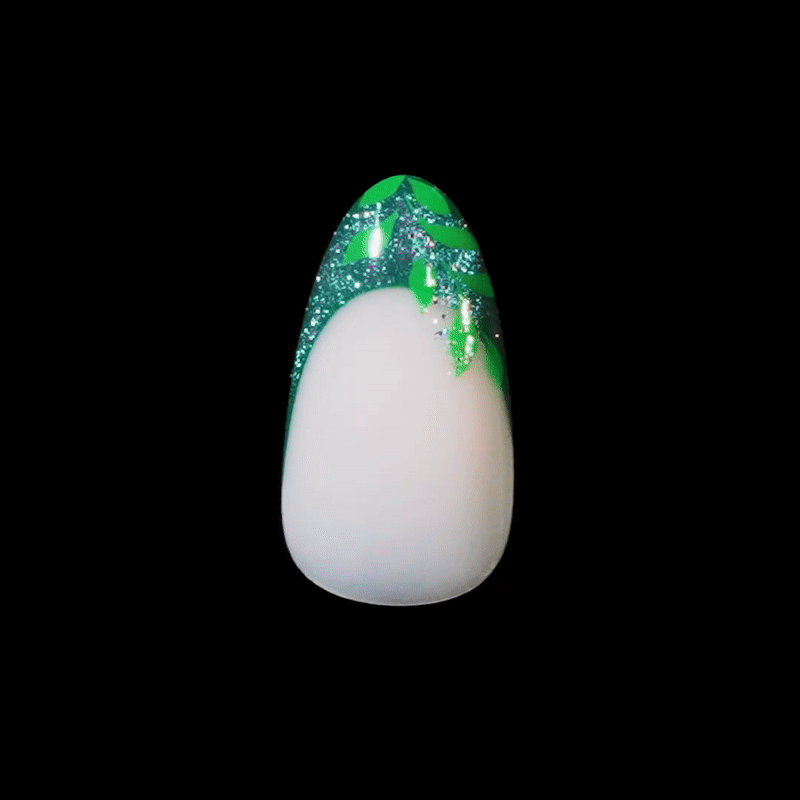 White egg-shaped object with green glittery top on black background