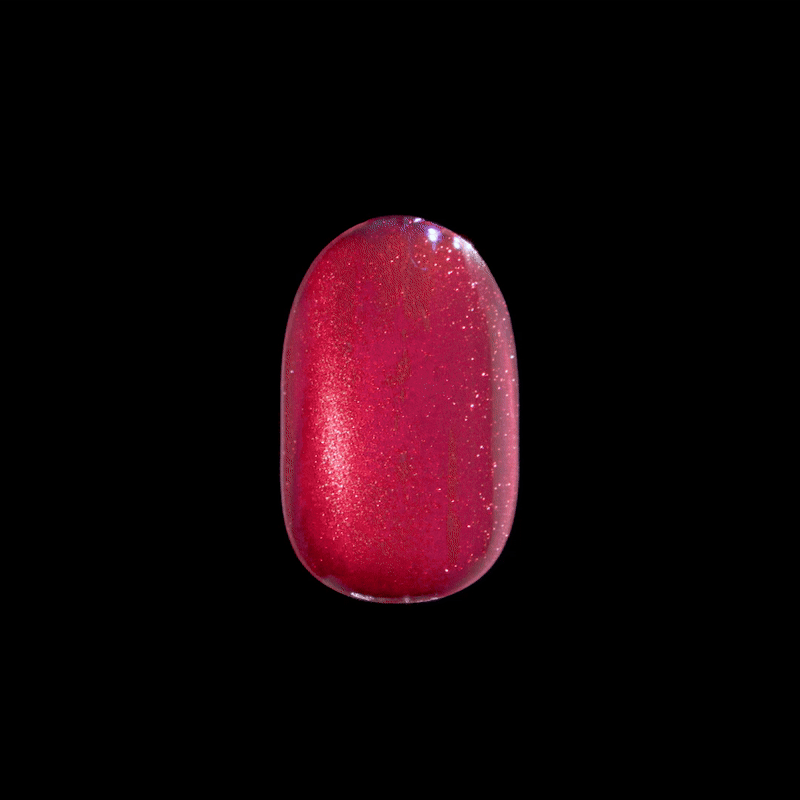 Bright shimmery raspberry red press-on nail with a glossy finish, shown against a black background.