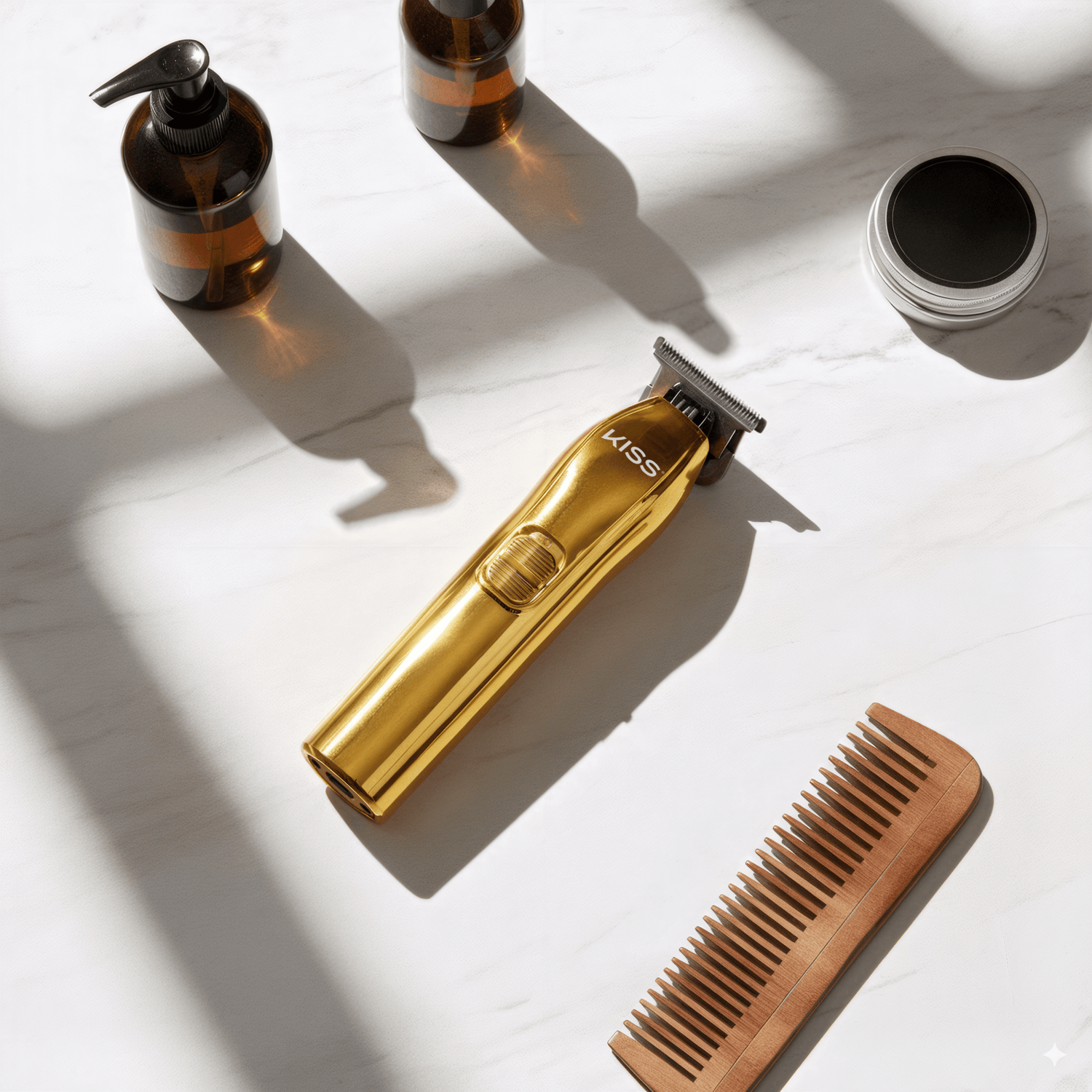 Gold cordless KISS T-blade beard and hair trimmer placed on a white marble surface, surrounded by a wooden comb, amber pump bottles, and a silver tin container.