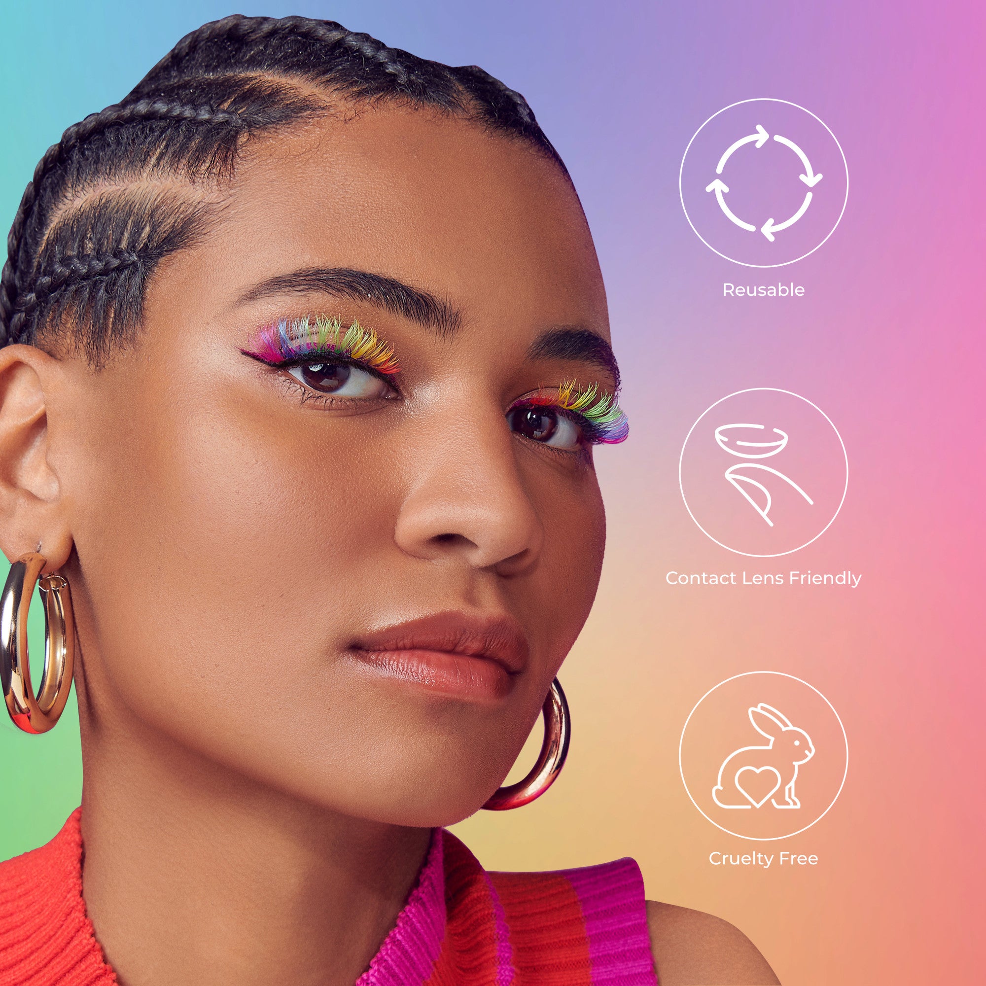 Close-up of a woman with braided hair wearing gold hoop earrings and vibrant rainbow-colored false eyelashes on a gradient background. Text includes reusable, contact lens friendly, and cruelty free icons.