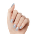 Hand wearing press-on nails with a translucent base and multi-colored glitter pieces, featuring a rounded square shape.