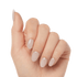 Hand with natural-looking, oval-shaped press-on gel nails in a soft nude beige color, shown from a side angle with fingers slightly curled.