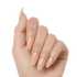 Glossy, press-on gel nails in a soft peach nude shade named Limousine, shaped in a long coffin style on a hand with natural skin tone.