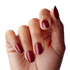 Close-up of a hand with medium-length, oval-shaped press-on nails in a rich, glossy deep red color.