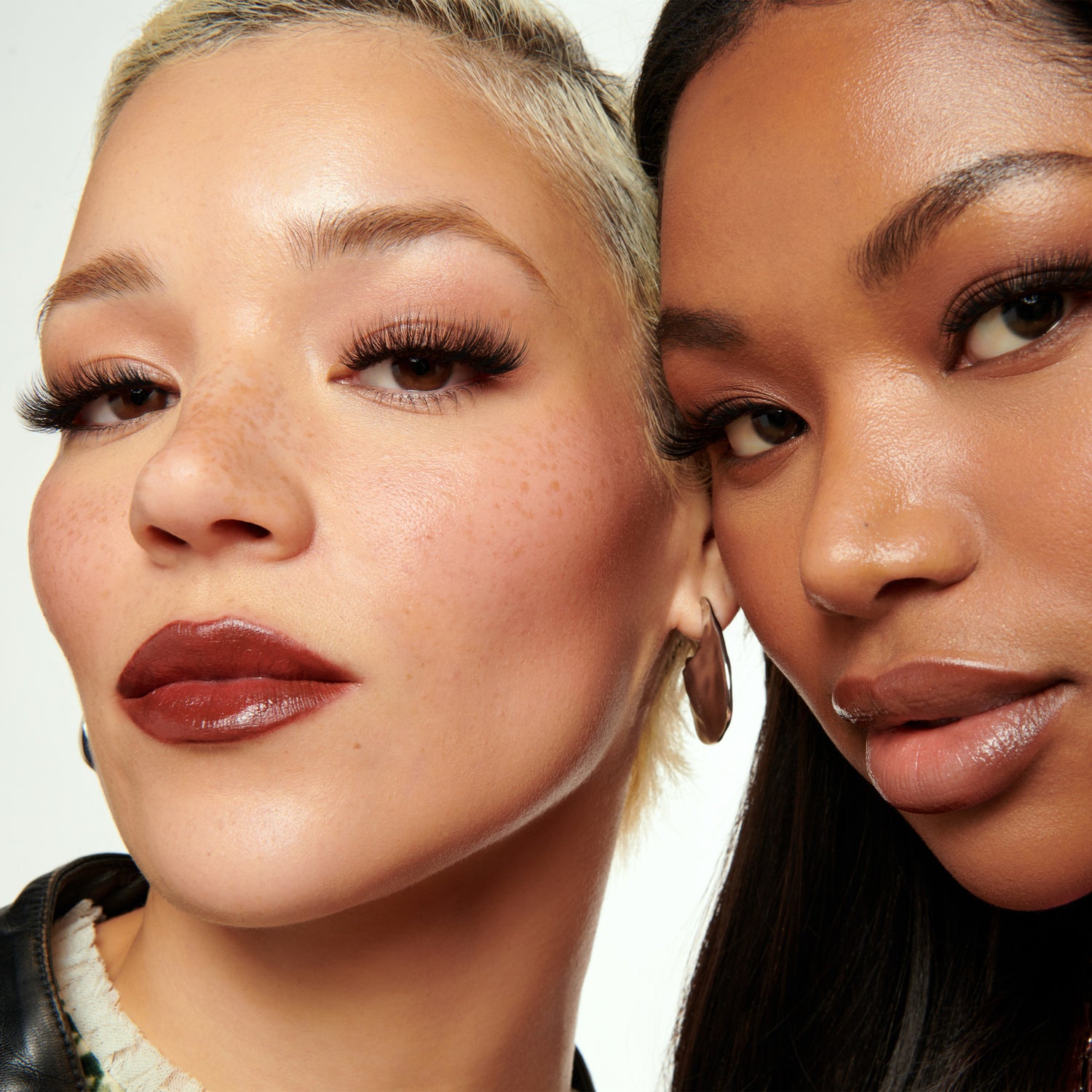 Two women with close-up faces, showcasing makeup and hairstyles.