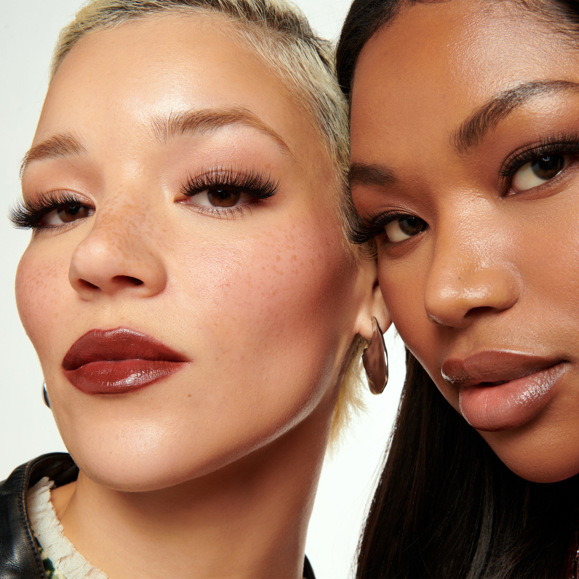 Two women with close-up faces, showcasing makeup and hairstyles.