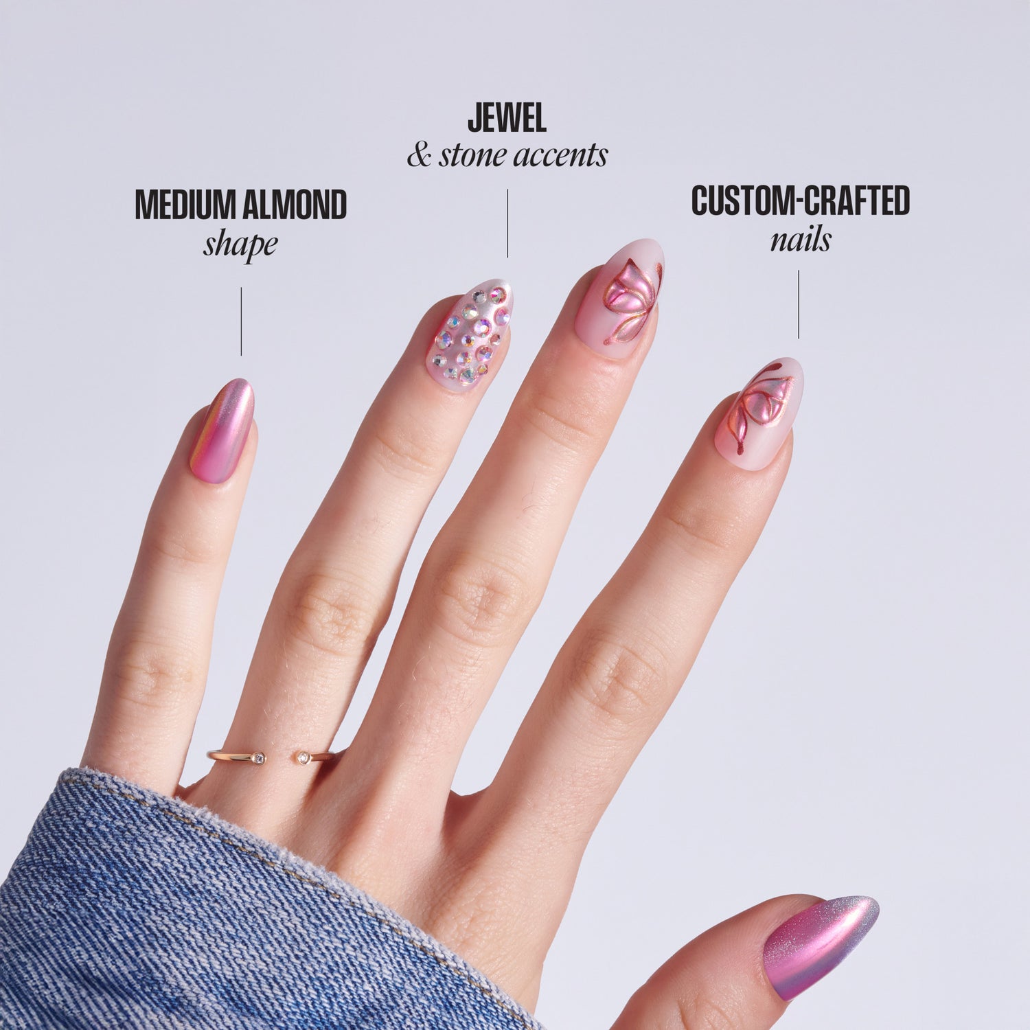 Hand displaying medium almond nails with jewel accents and custom nail art designs.