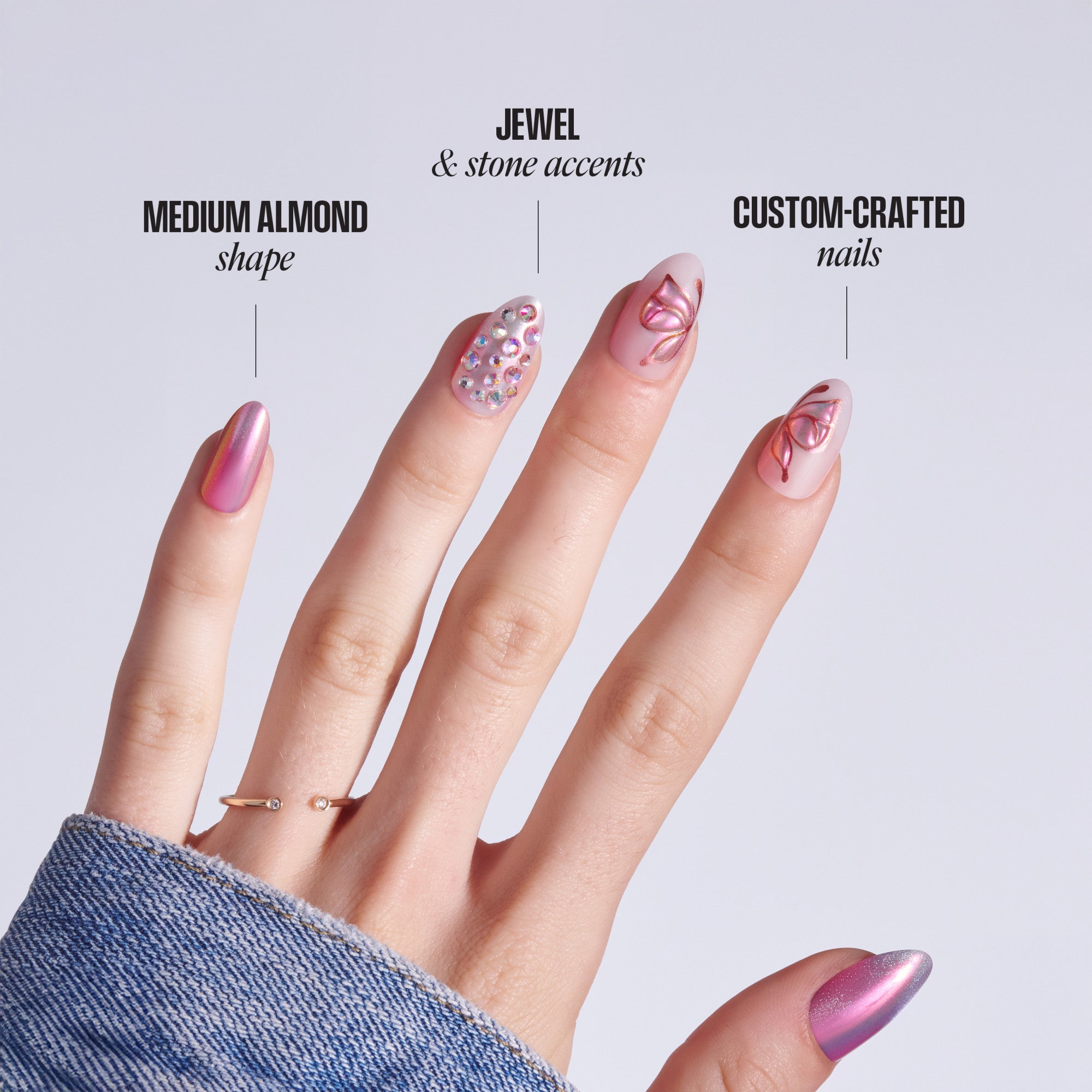 Hand displaying medium almond nails with jewel accents and custom nail art designs.