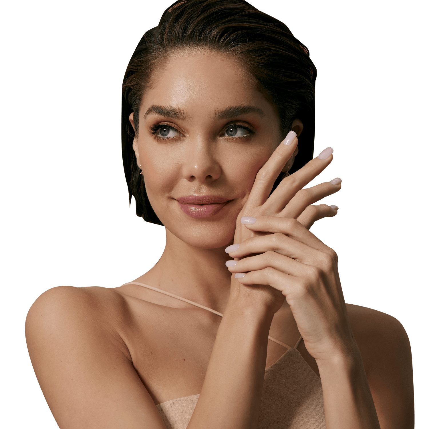 Woman with short dark hair and blue eyes wearing a nude strap top, showing hands with short, glossy nude-colored press-on nails.