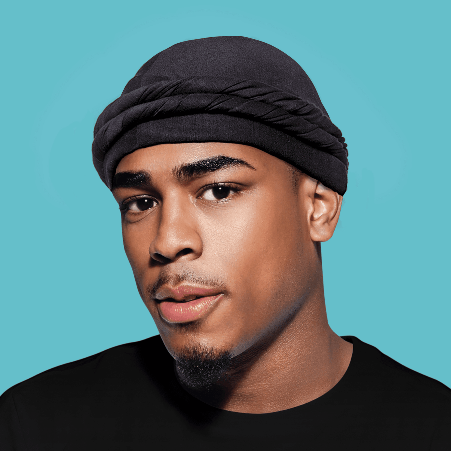 Black satin-lined halo turban worn by a man against a teal background, showing the turban&