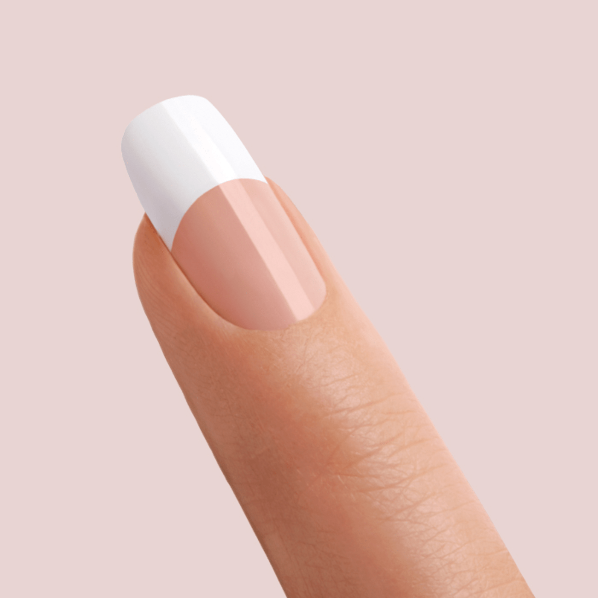 A close-up of a fingernail with a French manicure style featuring a natural pink base and a glossy white tip, set against a soft pink background.