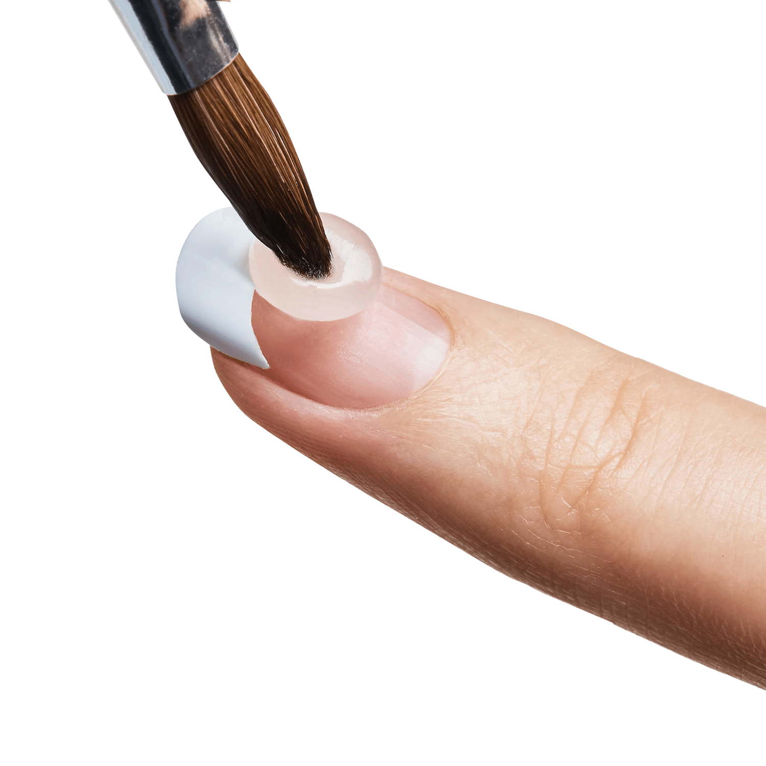 Close-up of a finger with a white acrylic nail tip being filled using a small round brush applying clear acrylic gel.